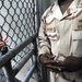 The Joint Detention Group barber, a Navy Ship's Serviceman, speaks to a detainee about trimming his beard in Camp VI