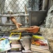 A soldier from the detainee library hands a periodical to a detainee in Camp Five