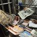 A detainee takes a newspaper given to him from a guard in Camp Five