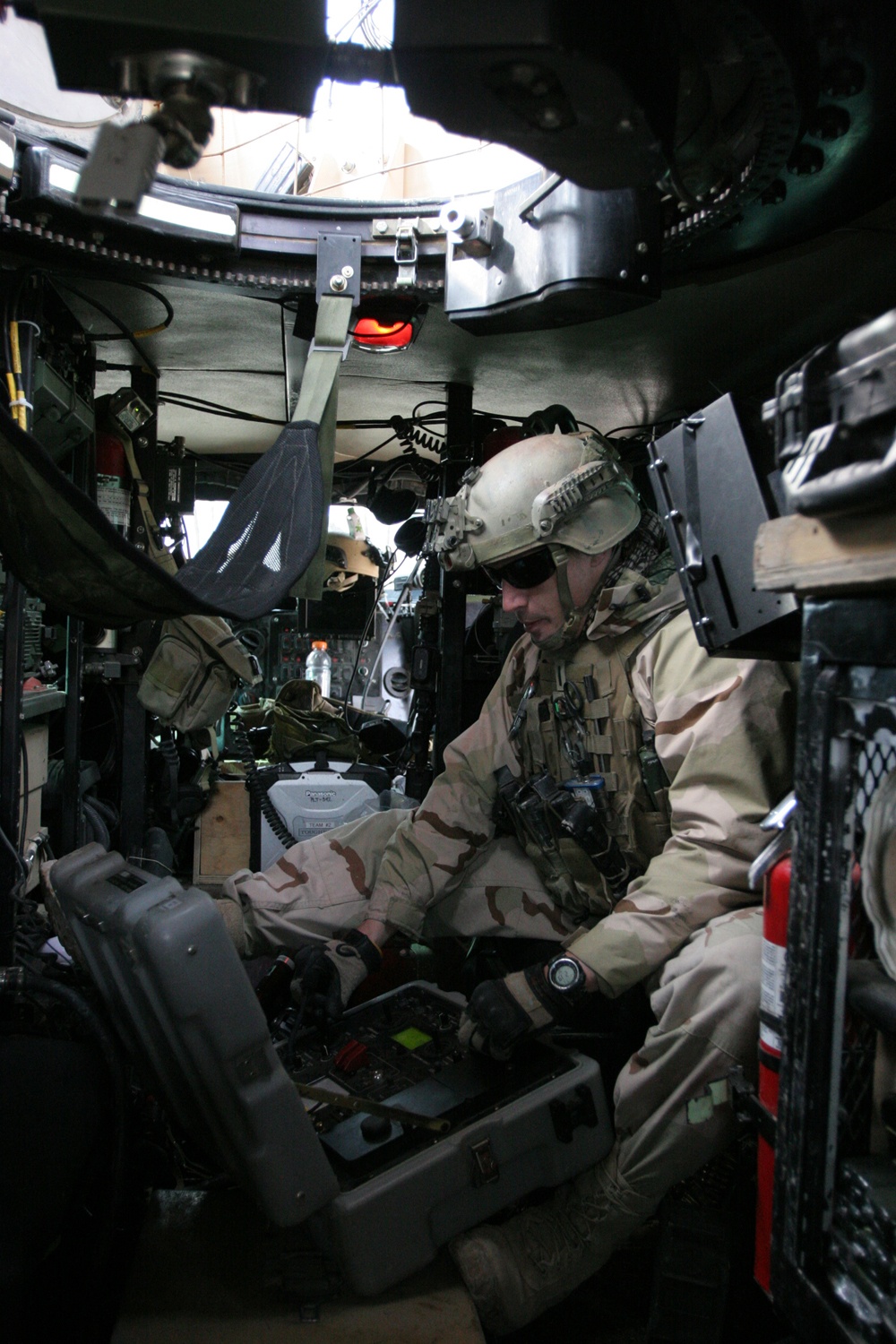 A US Navy EOD technician operates a remote-controlled robot inspecting and handling a simulated IED