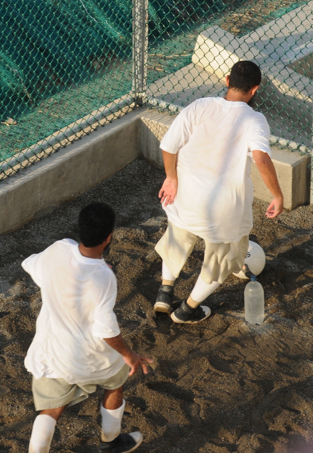 Detainees play soccer within the outdoor recreation area of Camp Six at Joint Task Force Guantanamo