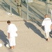 Two detainees walk around and another gets ready to kick a soccer ball within the outdoor recreation area of Camp Six at Joint Task Force Guantanamo