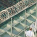 A detainee walks within the outdoor recreation area of Camp Six at Joint Task Force Guantanamo