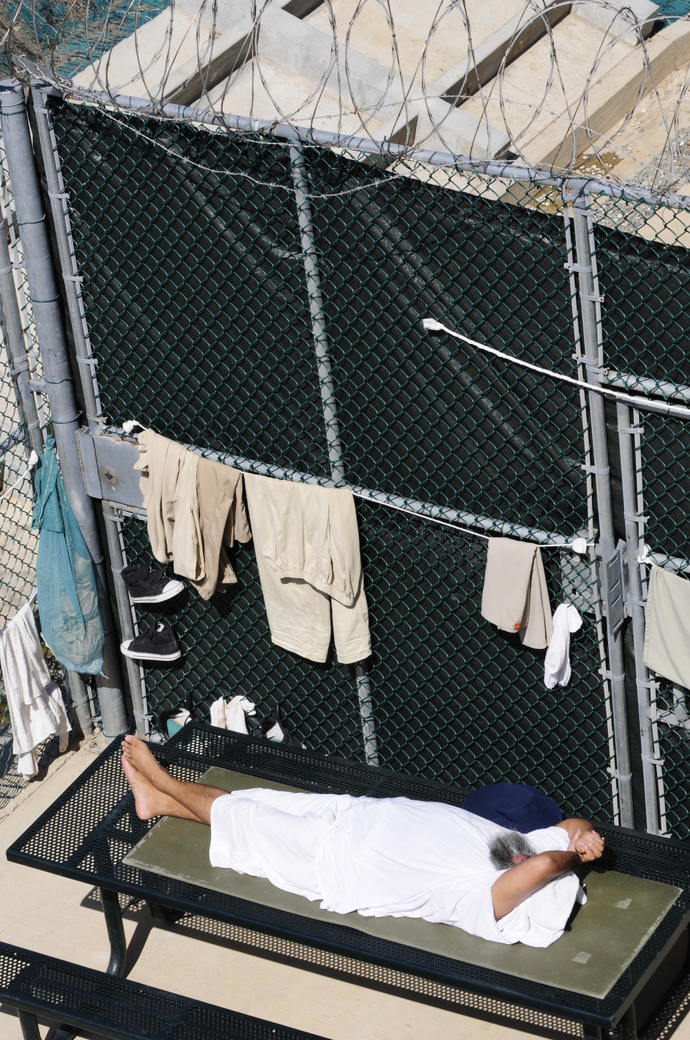 A detainee rests in the outdoor recreation area of Camp Six at Joint Task Force Guantanamo