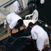 Two detainees wash a mat in the outdoor recreation area of Camp Six at Joint Task Force Guantanamo