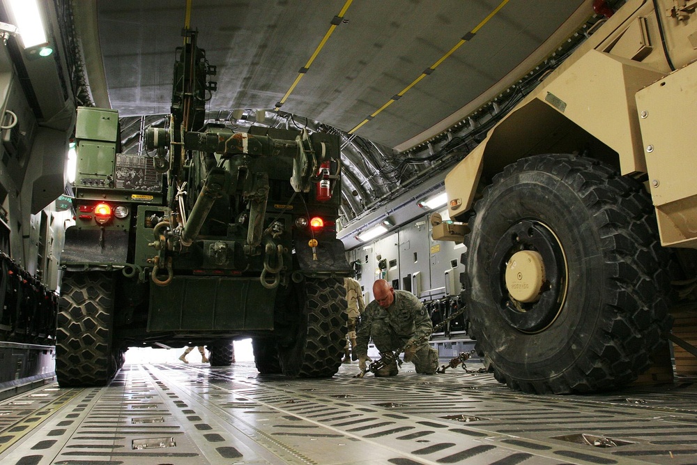 Trucks back into a C-17 aircraft for transport
