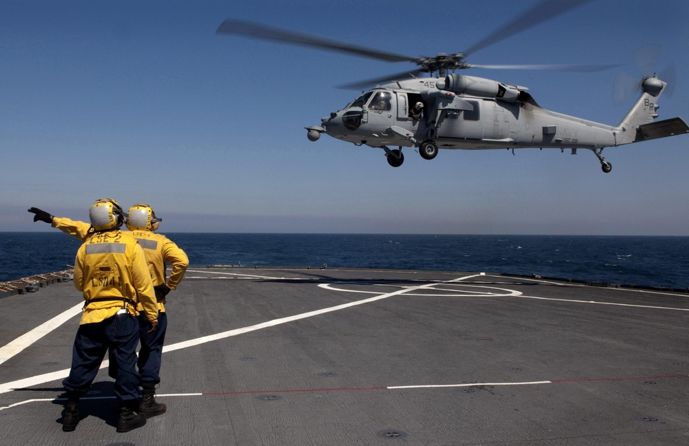 Sailor Directs MH-60S Sea Hawk Aboard USS Whidbey Island