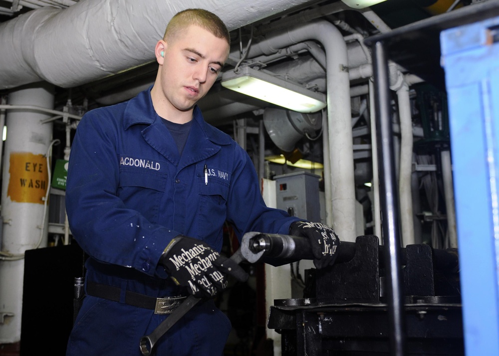 USS Kearsarge Sailor Works on Burner Barrel