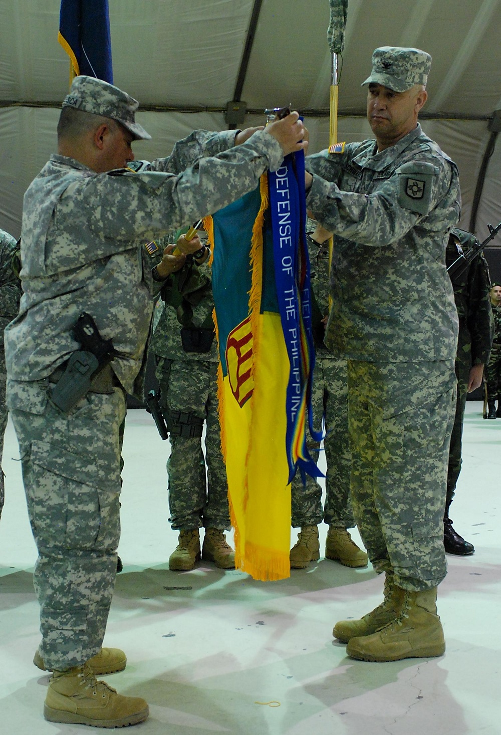 Incoming commander and sergeant major uncase their colors during transfer of authority ceremony in Kosovo