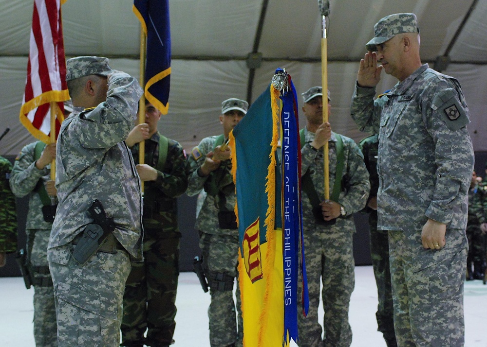 Incoming commander and sergeant major uncase their colors during transfer of authority ceremony in Kosovo