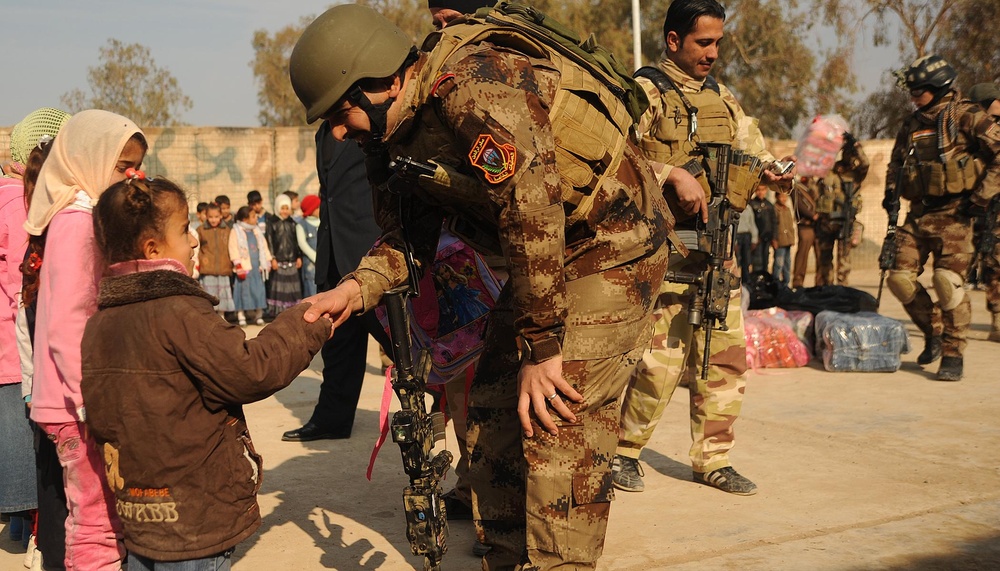 Iraqi special operations forces hand out backpacks