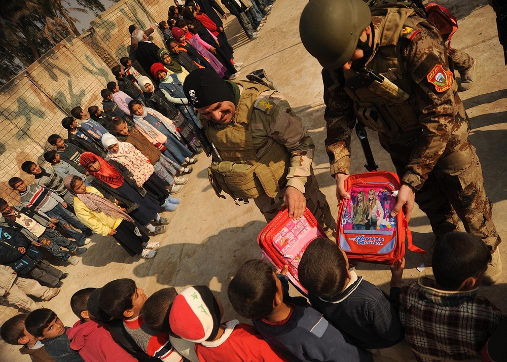 Iraqi special operations forces hand out backpacks