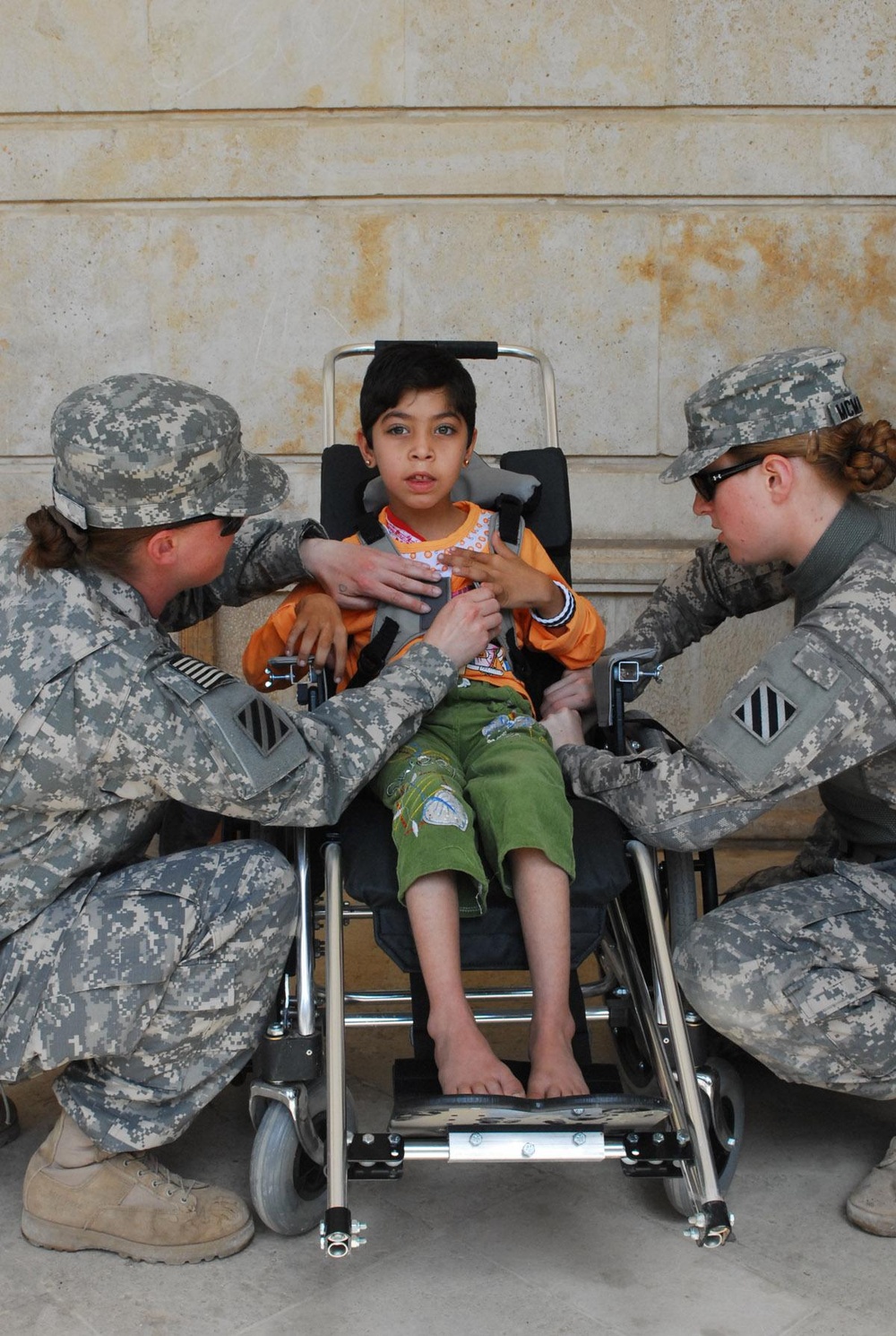 Vanguard Brigade Soldiers help distribute wheelchairs to disabled Iraqi children