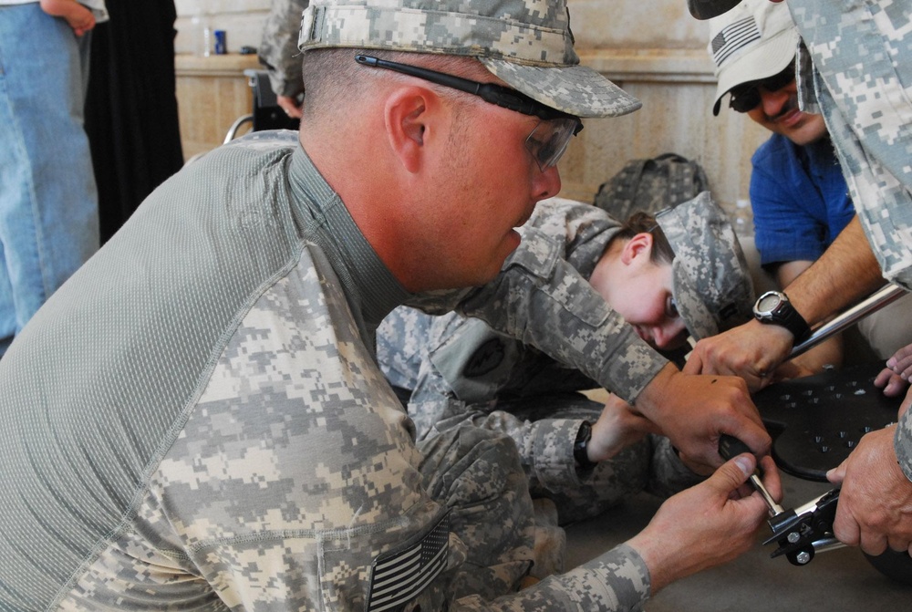 Vanguard Brigade Soldiers help distribute wheelchairs to disabled Iraqi children