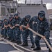 Sailors take in the aft storm line as USS Forrest Sherman gets underway.