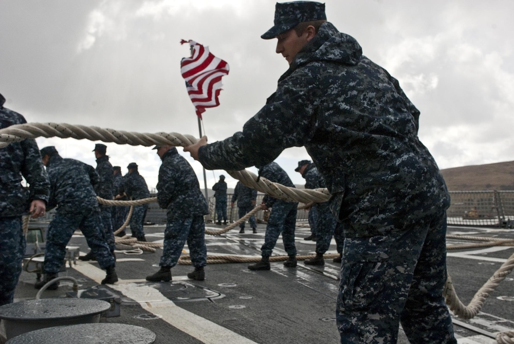 Seaman Brian Crawford takes in mooring line four as USS Forrest Sherman gets underway.