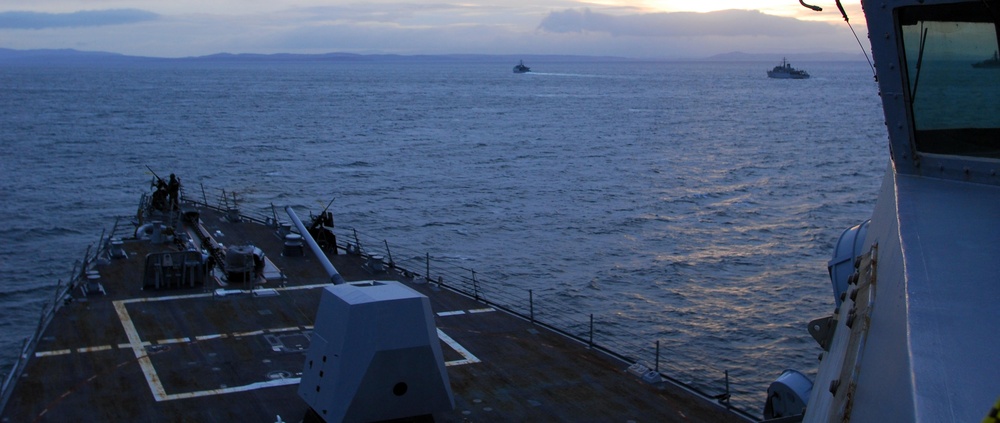 Canadian mine sweepers sit off the starboard bow of guided missile destroyer USS Forrest Sherman (DDG 98) during a fast attack craft drill.