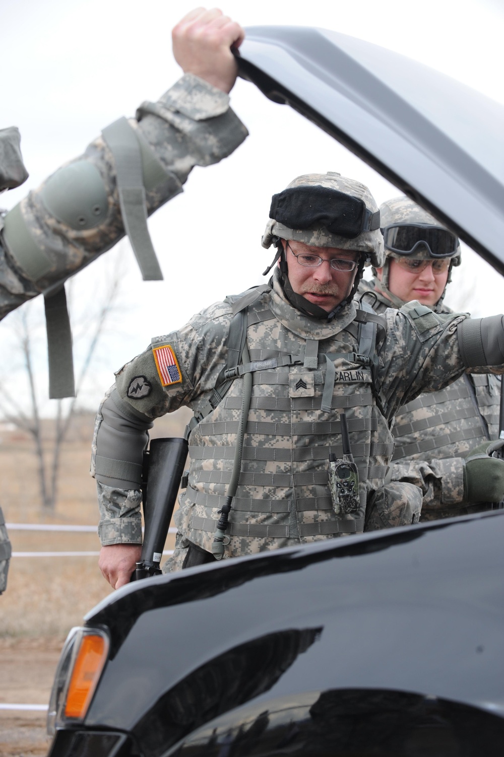 Sgt. Shawn M. Carlin with the South Dakota Army National Guard's 842nd Engineer Company inspects the engine of a vehicle while conducting an Entry Control Point training scenario