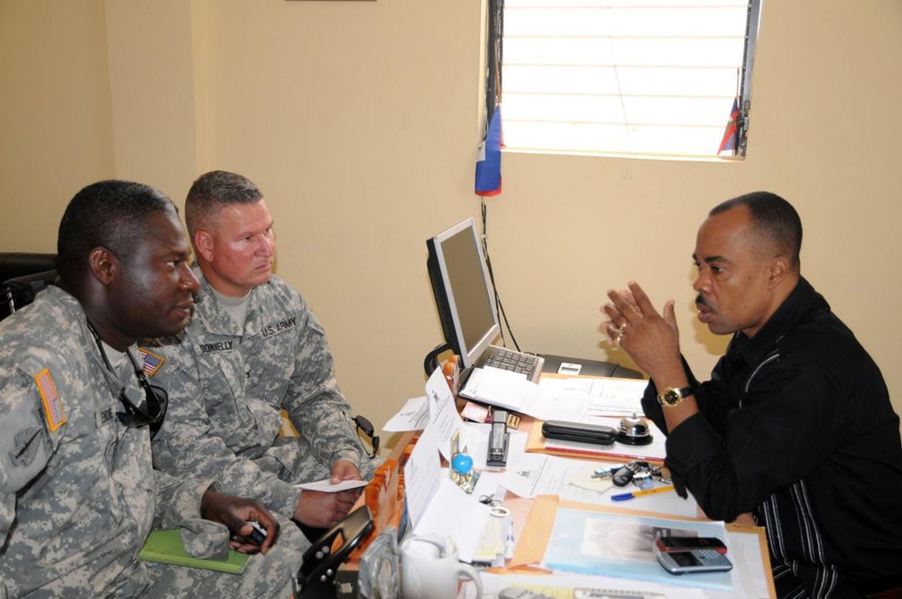 Louisana Guardsman, Col. Kenneth Donnelly, commander Task Force Bon Voizen, discusses task force missions with the director-general of the Artibonite police department.