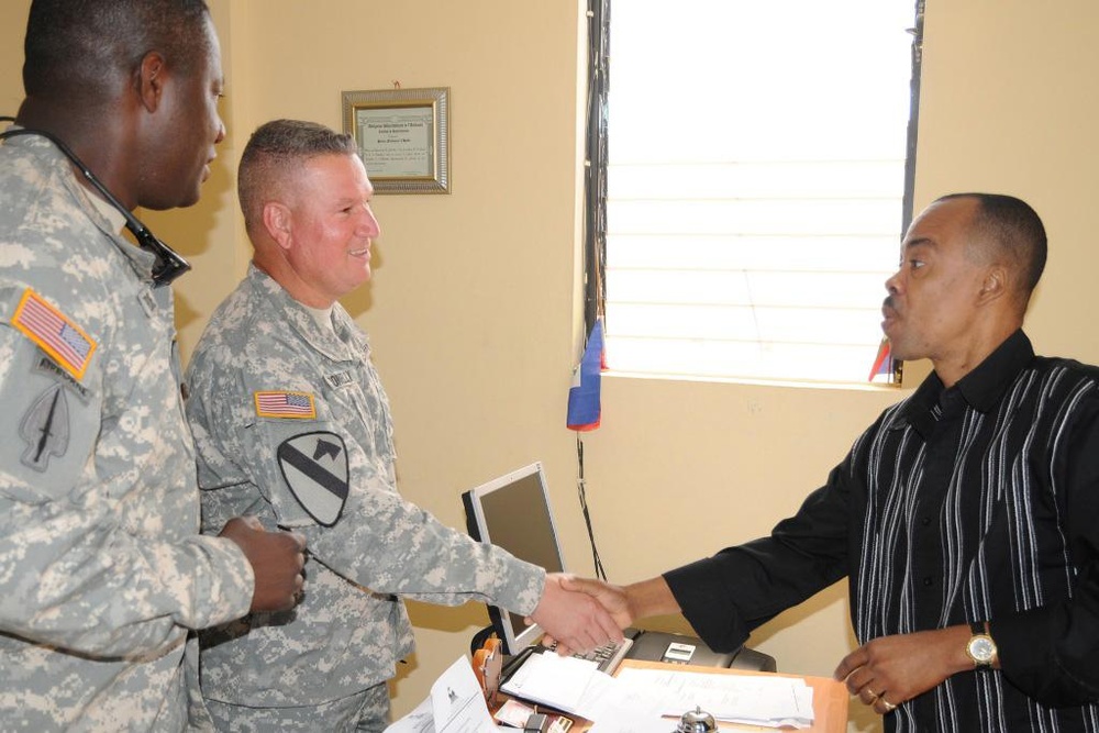 Col. Kenneth Donnelly, commander Task Force Bon Voizen, shakes hands with the director-general of the Artibonite police department