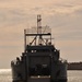 Service members watch as U.S. Army vessel Landing Craft Utility 2006