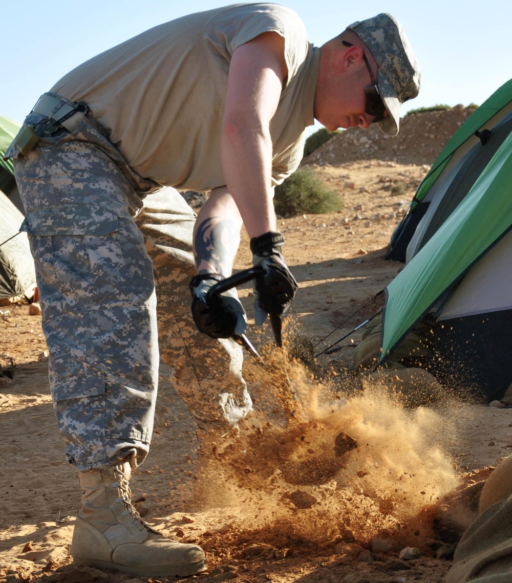 Soldier digs trench around his tent