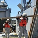 Soldiers unload wood off of Army vessel