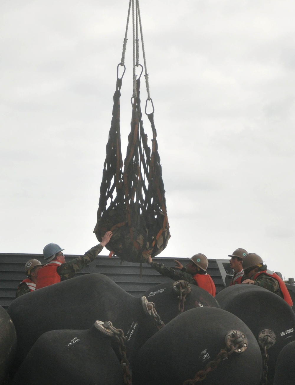 Sailors unload equipment from the U.S. Naval Ship Pillilaau