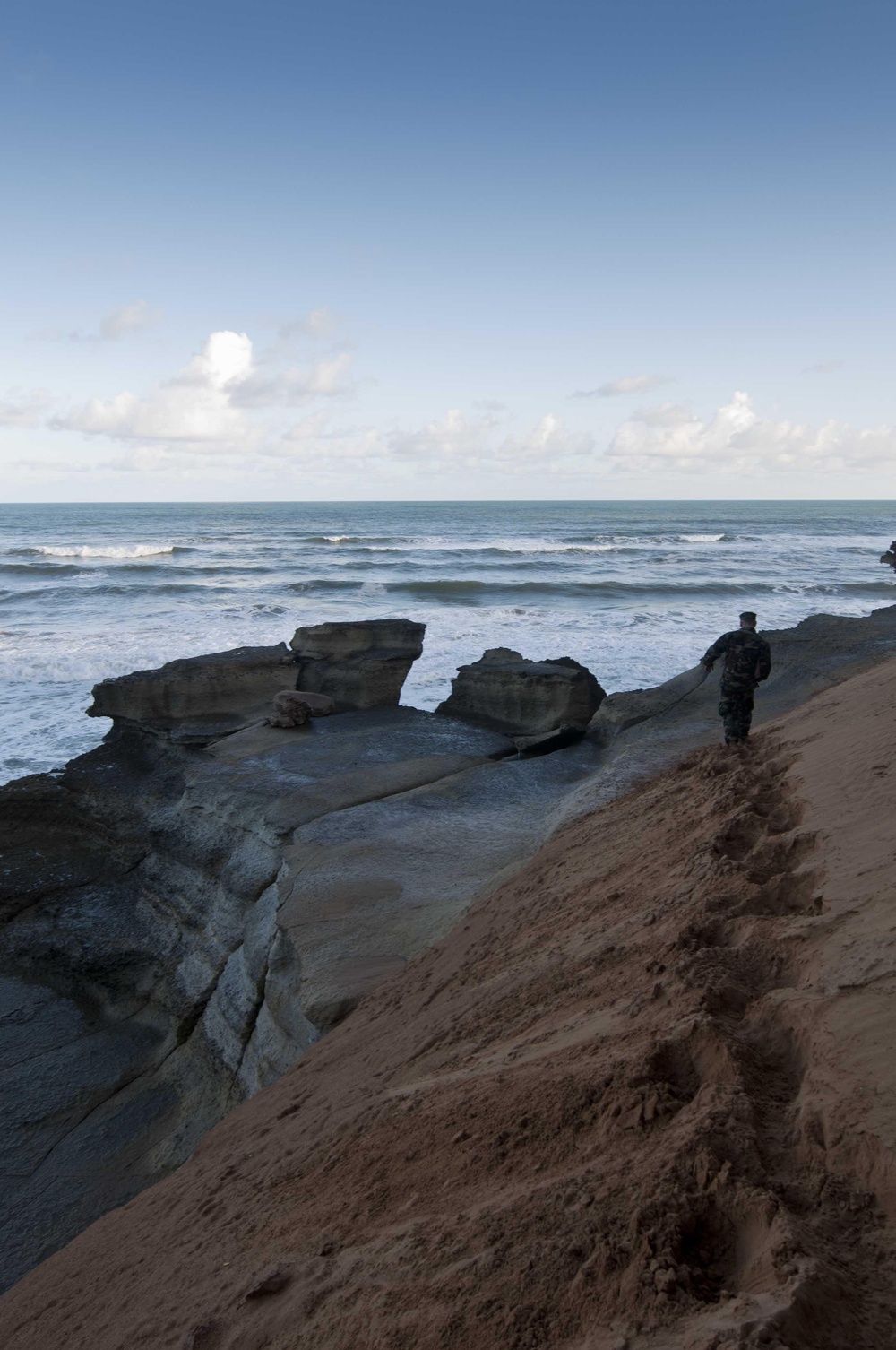 A Seabee participating African Lion walks the beach