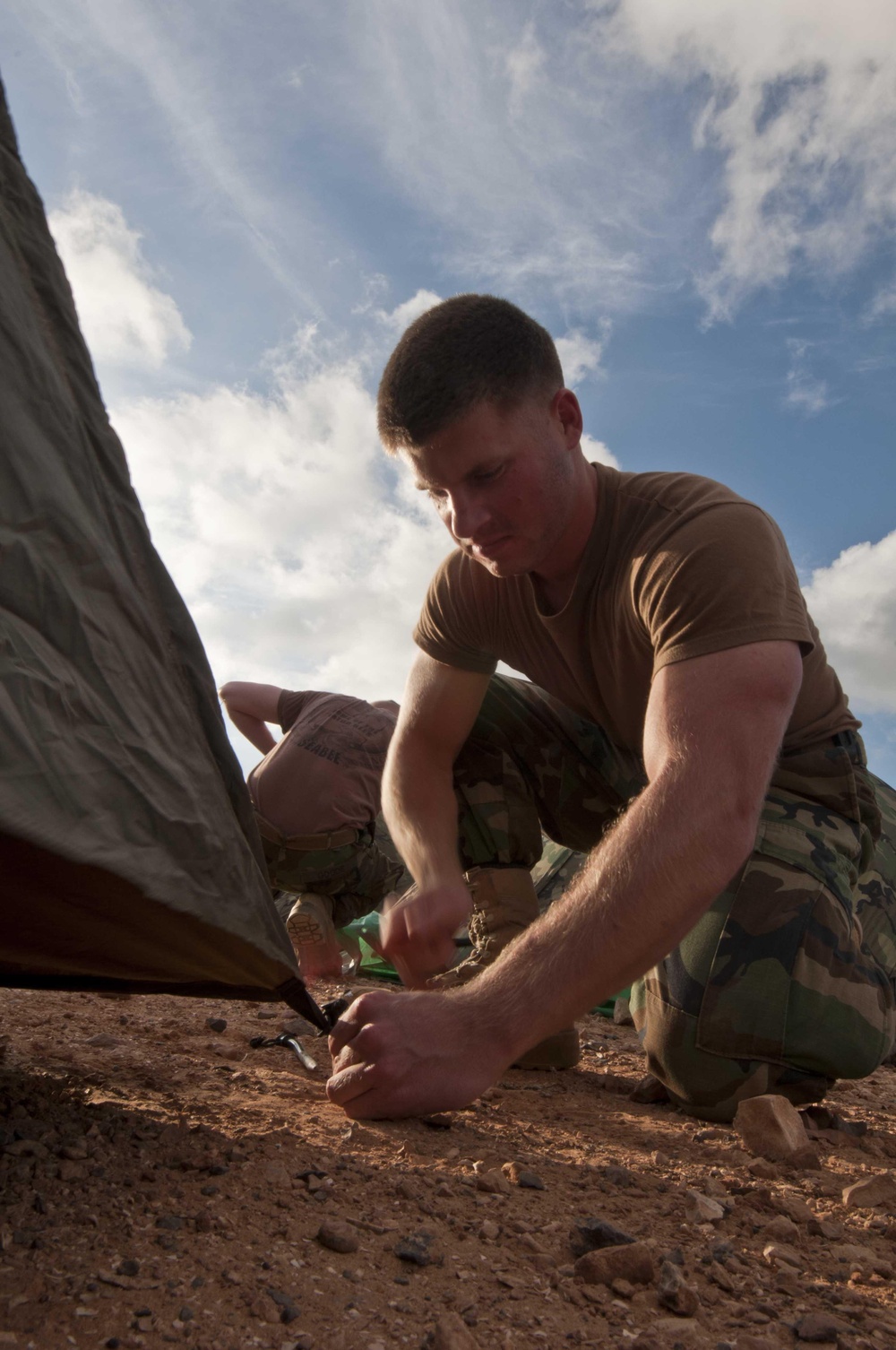 Seabee hammers tent stake at JLOTS base camp