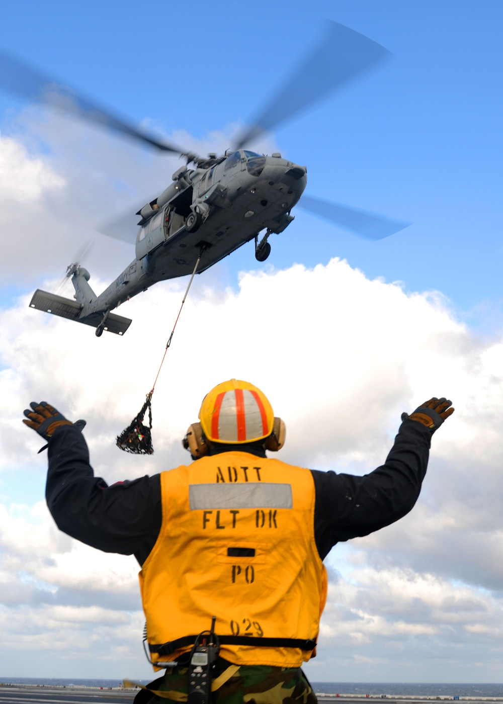 Sailor signals MH-60S Sea Hawk