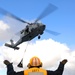 Sailor signals MH-60S Sea Hawk