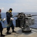 USS Frank Cable sailors load rounds into machine gun