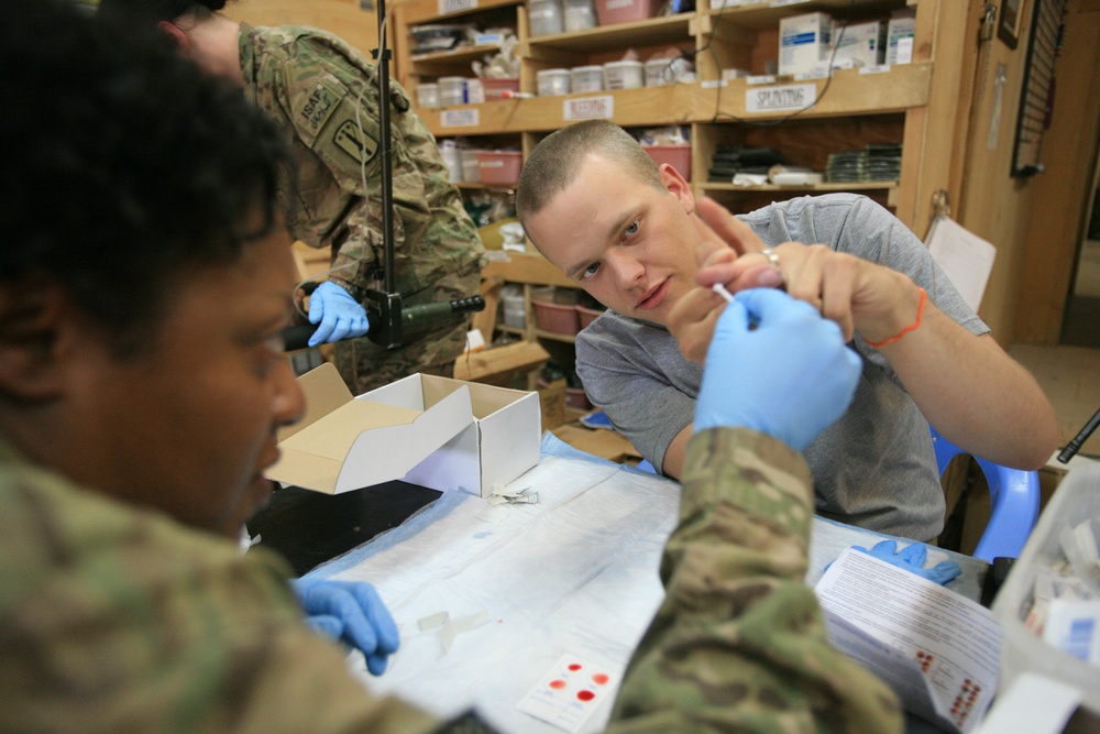 U.S. Army Medics train in applying intravenous solution on mock patients