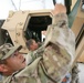 Soldiers fix a door on a vehicle