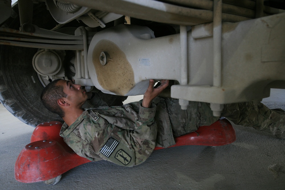 Under an armored truck performing maintenance