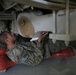 Under an armored truck performing maintenance