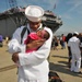 Seaman Demontay Blue holds his daughter for the first time during the amphibious assault ship USS Kearsarge return to Naval Station Norfolk