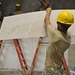 Soldiers place gypsum board on school wall in Cambodia