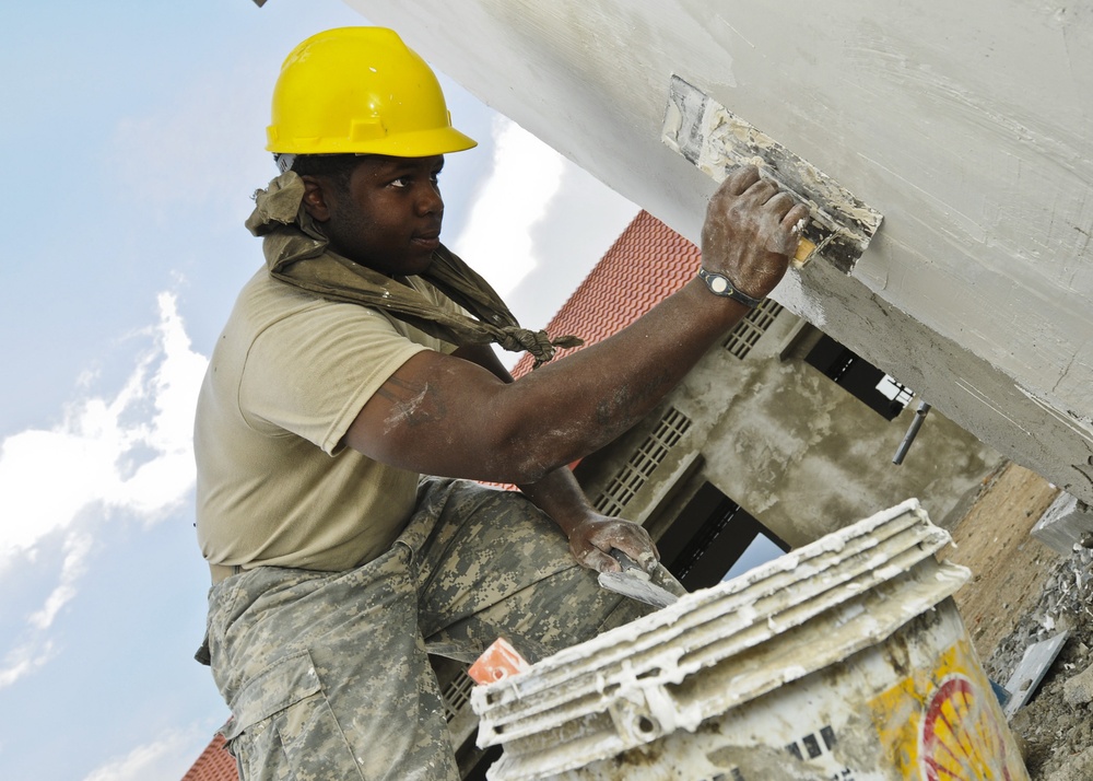 US Soldier applies plaster to latrine wall