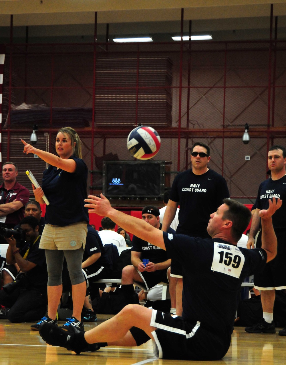Navy/Coast Guard team member serves during volleyball match