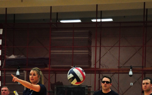 Navy/Coast Guard team member serves during volleyball match