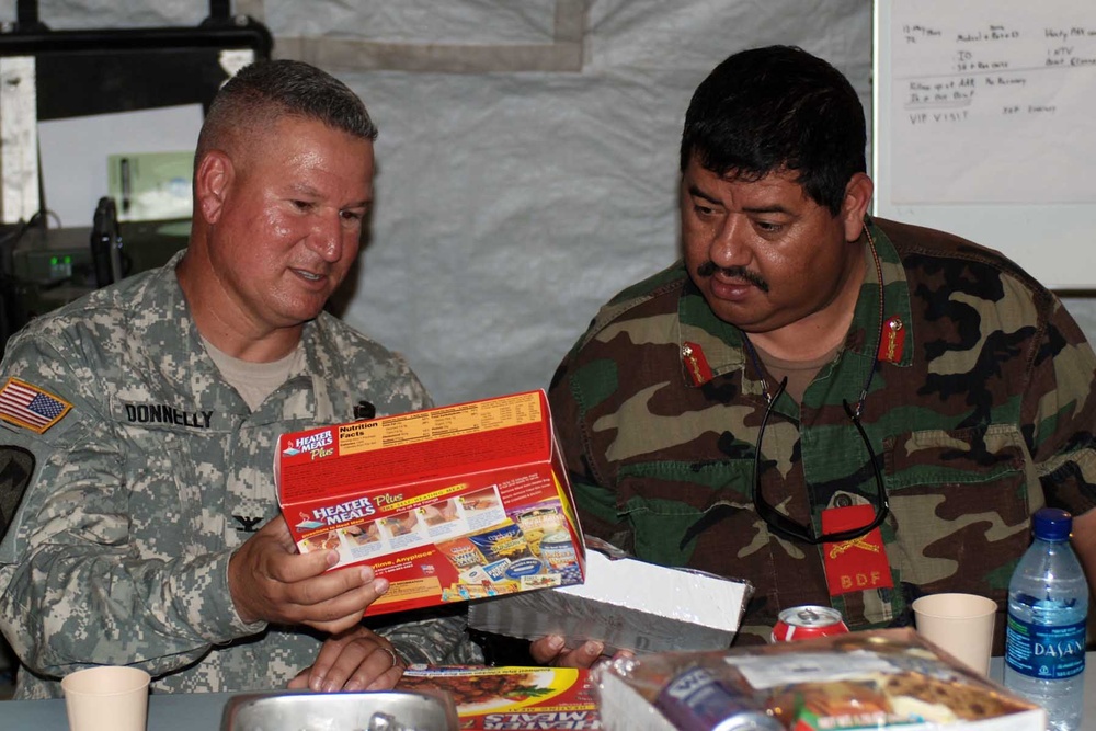 Brig. Gen. Oscar Tapia, Belize Defense Force Commander, and Col. Kenneth Donnelly, Task Force Bon Voizen Commander, discuss the merits of American processed food