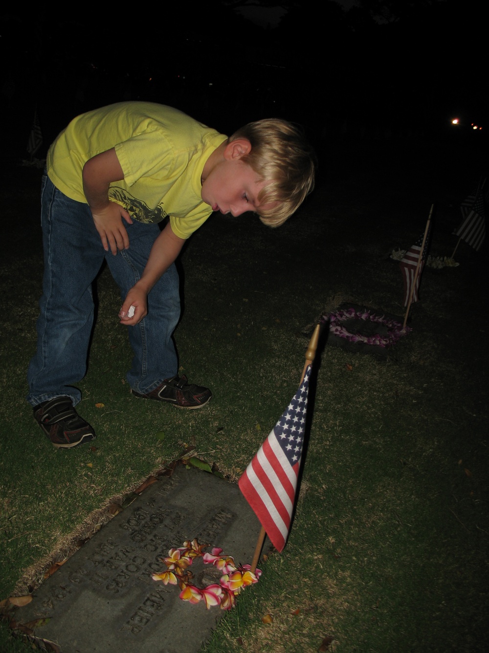 Nicholas Tovo reads headstone at National Memorial Cemetery of the Pacific in Honolulu Hawaii during Memorial Day Ceremony