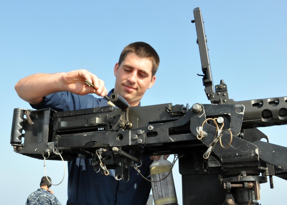 USS San Antonio sailor cleans machine gun
