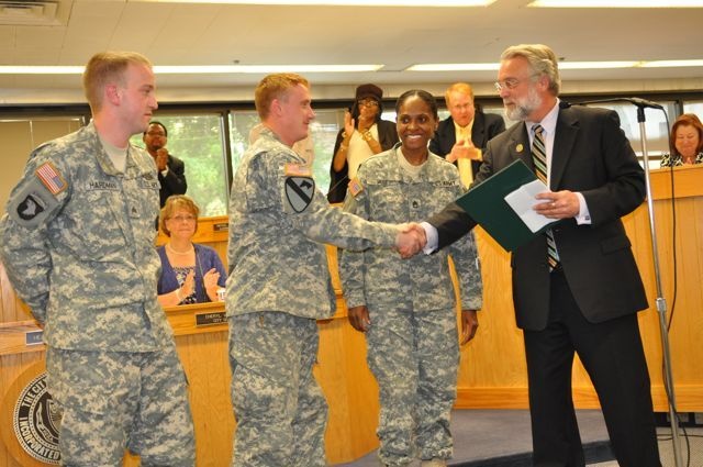 Aurora Mayor Tim Weisner shakes hands with Army recruiters