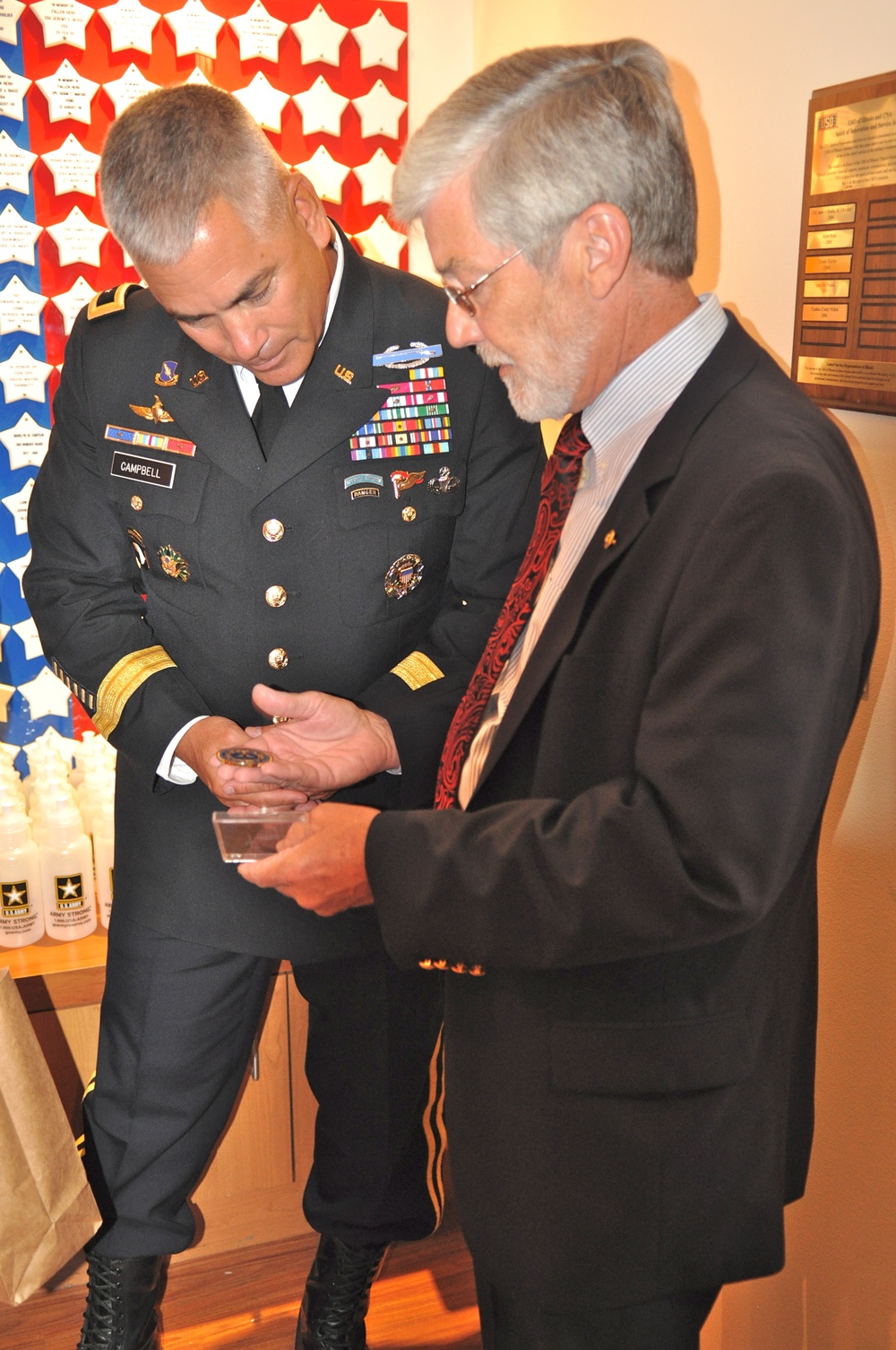 Jim Frazier, Survivor Outreach Services Coordinator gives Maj. Gen. Campbell a coin