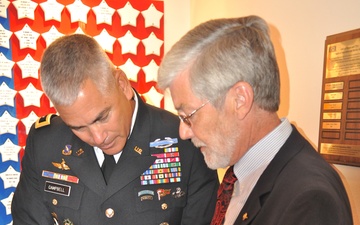 Jim Frazier, Survivor Outreach Services Coordinator gives Maj. Gen. Campbell a coin