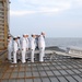 Sailors aboard USS Oak Hill commit to the sea the body of an honorably discharged Sailor during a burial at sea ceremony conducted from the edge of the ships stern gate