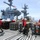Sailors aboard USS George Washington's flight deck prepare ordnance containers